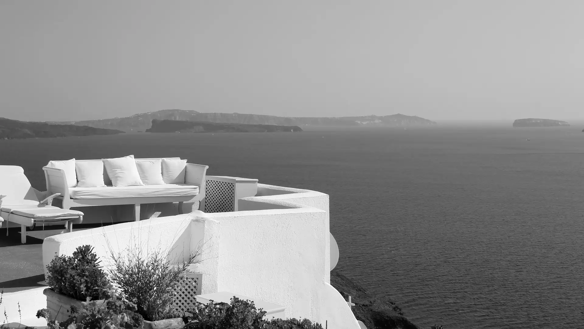 Black-and-white photograph of a whitewashed terrace above the Santorini caldera